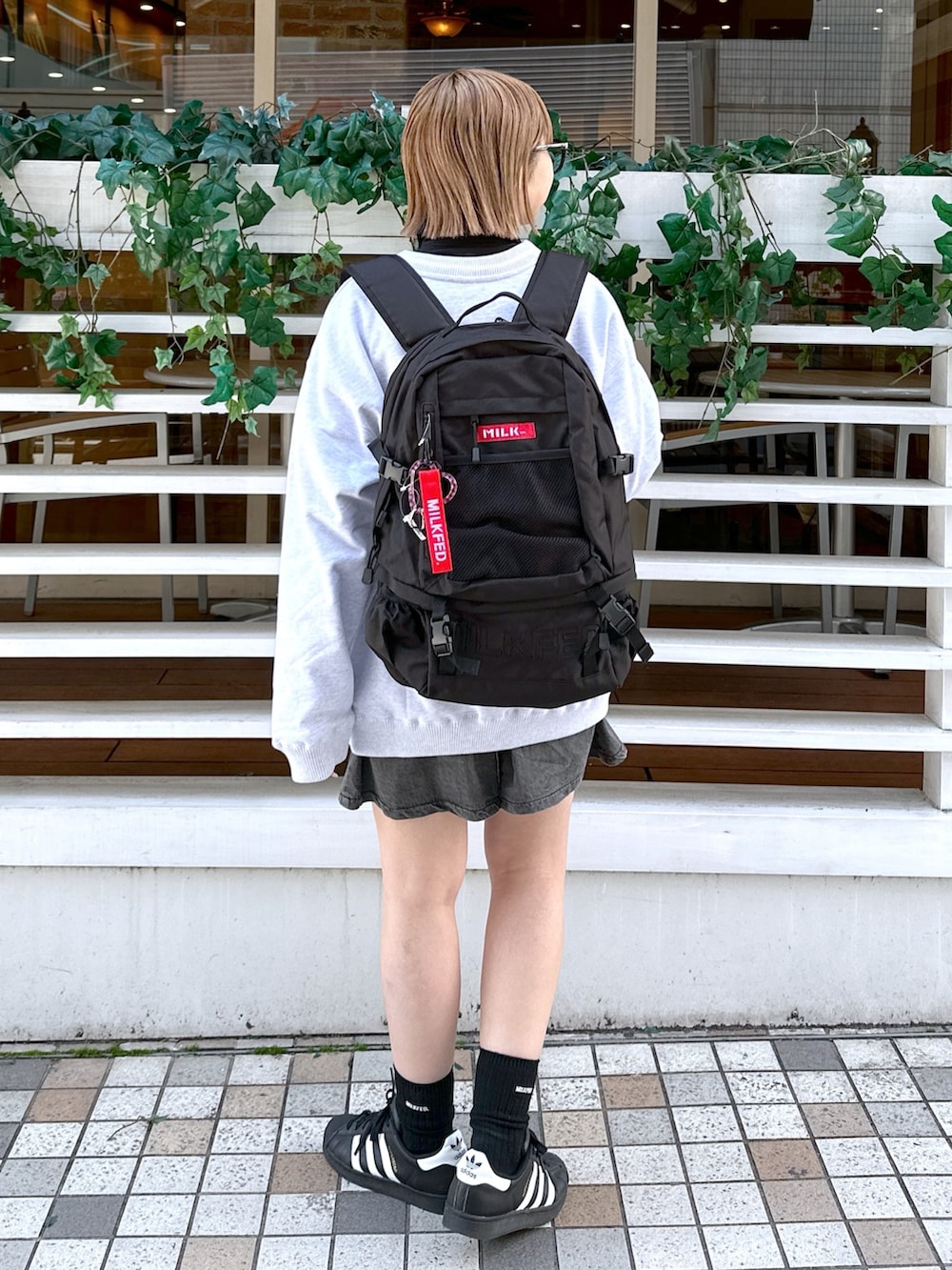 ブラック系のシャツ/ブラウス、レッド系のバックパック/リュック、グレー系のカーディガン/ボレロを着用したレディースの冬コーディネートの3枚目の写真