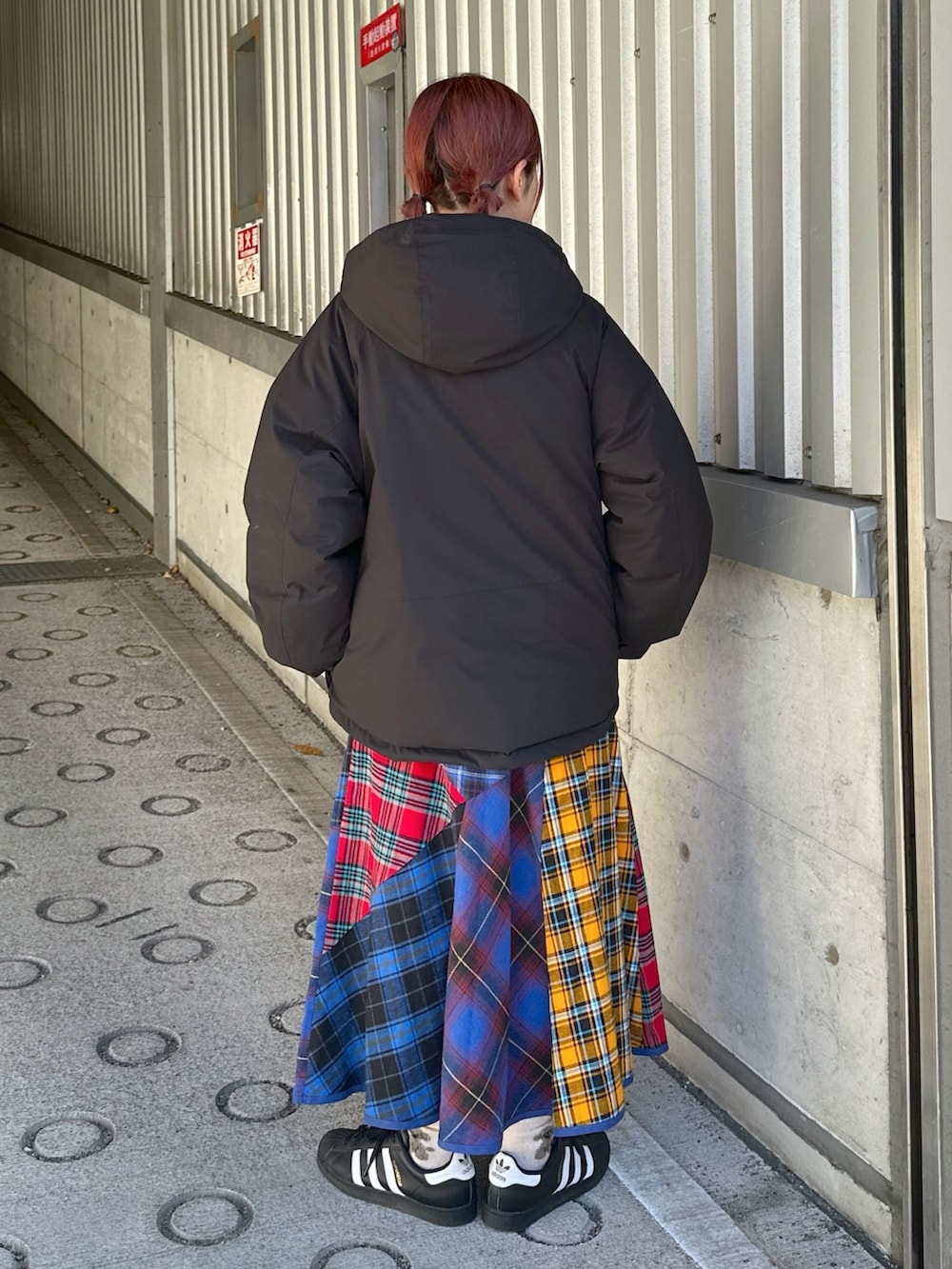 ブラック系のスウェット、ブラック系のダウンジャケット/コート、ブルー系のスカートを着用したレディースの冬コーディネートの2枚目の写真