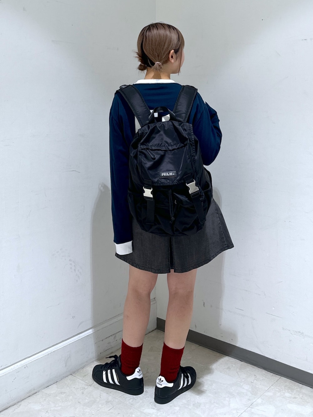 ブラック系のバックパック/リュック、ブルー系のTシャツ/カットソー、ブラック系のデニムスカートを着用したレディースの冬コーディネートの2枚目の写真