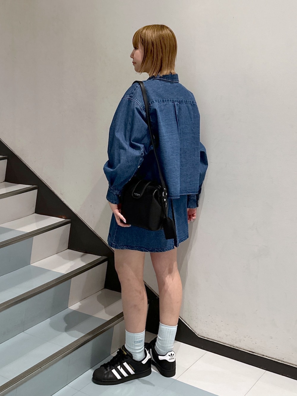 ブルー系のシャツ/ブラウス、ブラック系のショルダーバッグ、ホワイト系のTシャツ/カットソーを着用したレディースの春コーディネートの2枚目の写真