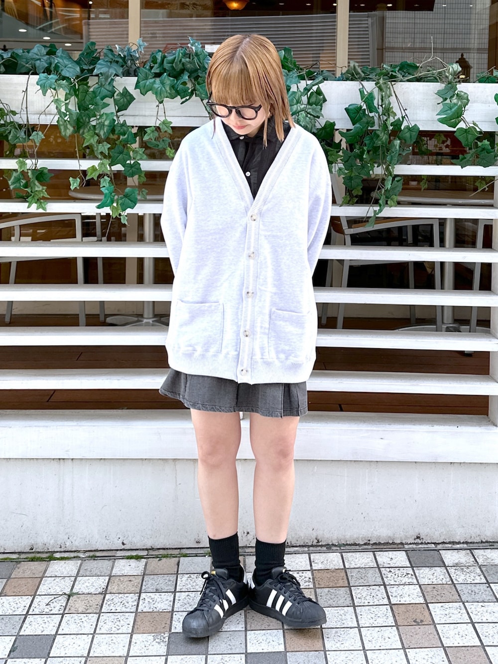 ブラック系のシャツ/ブラウス、レッド系のバックパック/リュック、グレー系のカーディガン/ボレロを着用したレディースの冬コーディネートの4枚目の写真