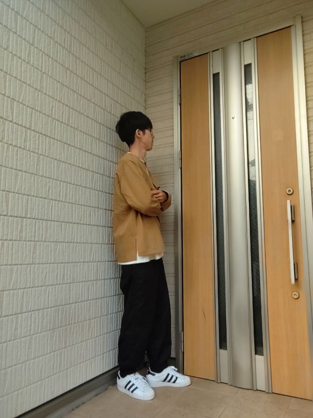 ホワイト系のスニーカー、ブラック系のその他パンツ、ホワイト系のTシャツ/カットソーを着用したメンズの夏コーディネートの2枚目の写真