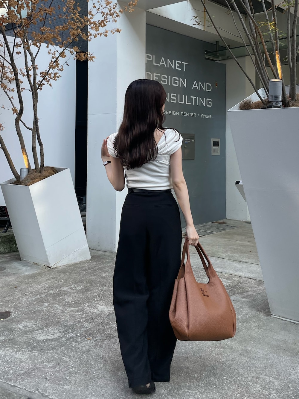 イエロー系のトートバッグ、ブラック系のその他パンツ、ブラック系のサンダルを着用したレディースの夏コーディネートの4枚目の写真