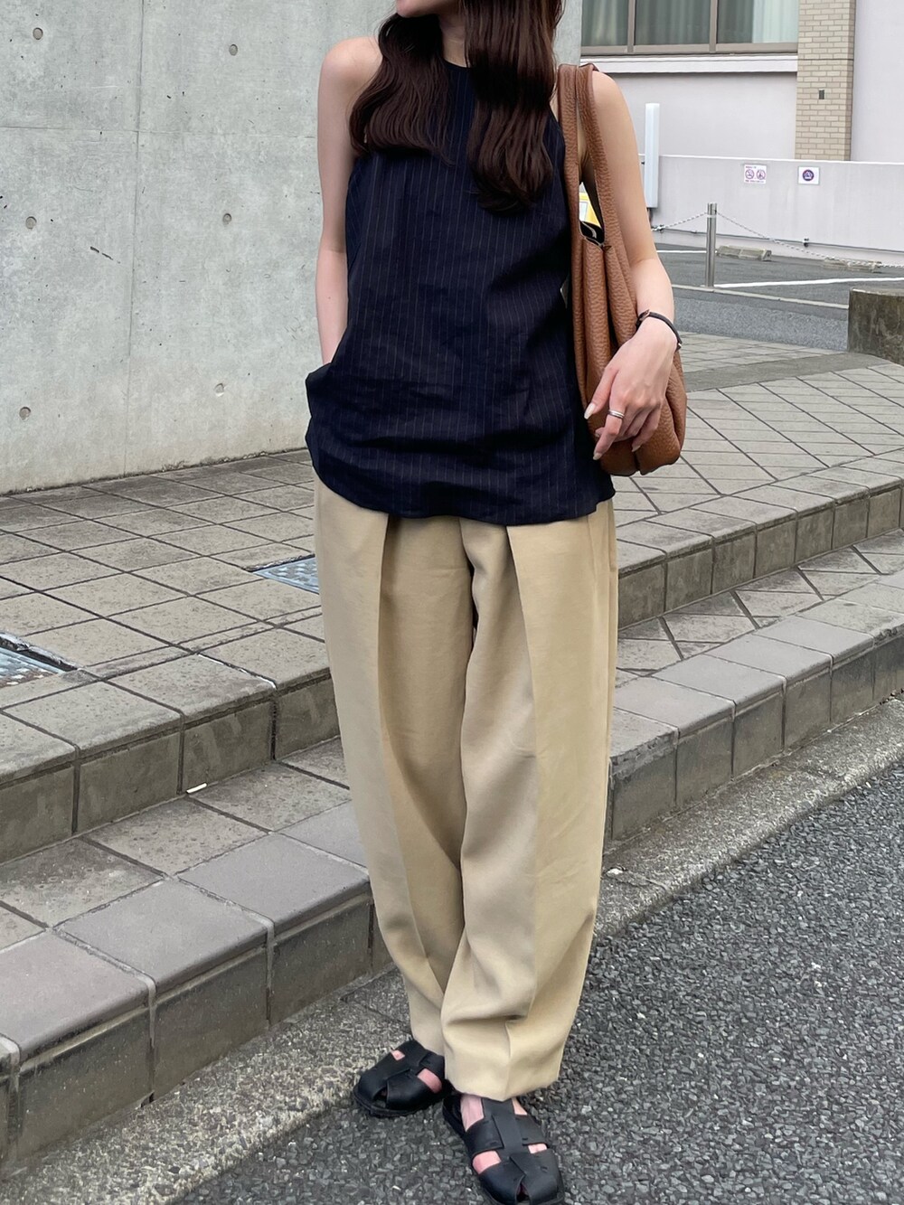 ベージュ系のパンツ、イエロー系のトートバッグ、ブルー系のトップスを着用したレディースの夏コーディネートの4枚目の写真