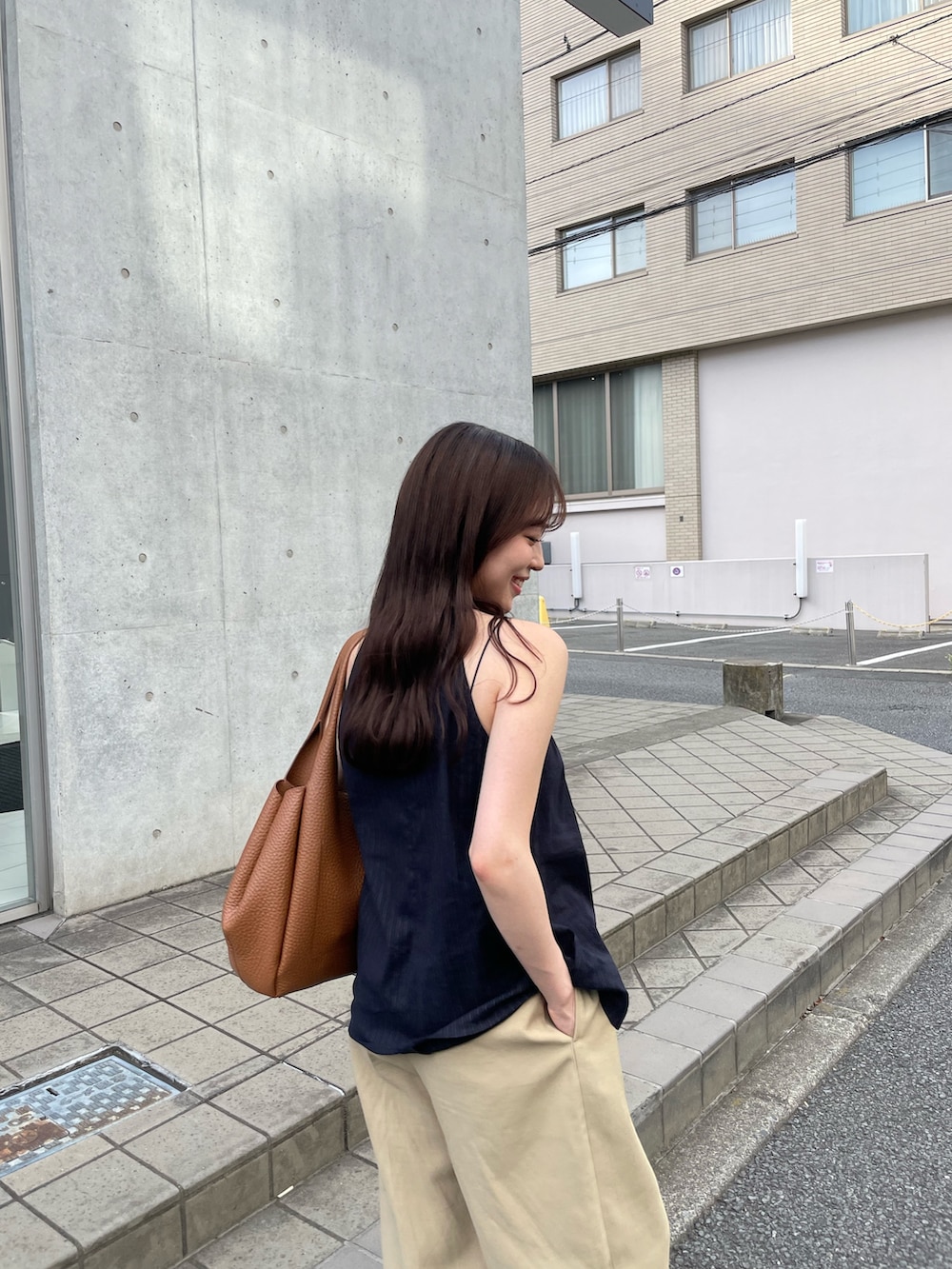 ベージュ系のパンツ、イエロー系のトートバッグ、ブルー系のトップスを着用したレディースの夏コーディネートの3枚目の写真