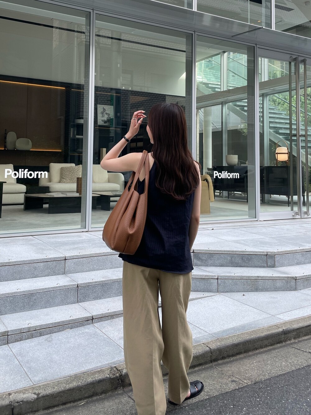 ベージュ系のパンツ、イエロー系のトートバッグ、ブルー系のトップスを着用したレディースの夏コーディネートの2枚目の写真