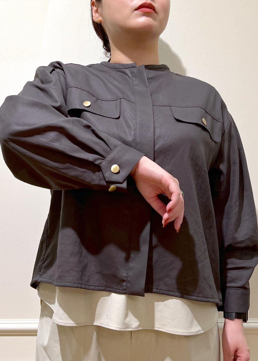 ブラック系のハンドバッグ、ベージュ系のシャツ/ブラウス、ブラック系のサンダルを着用したレディースの夏コーディネートの6枚目の写真