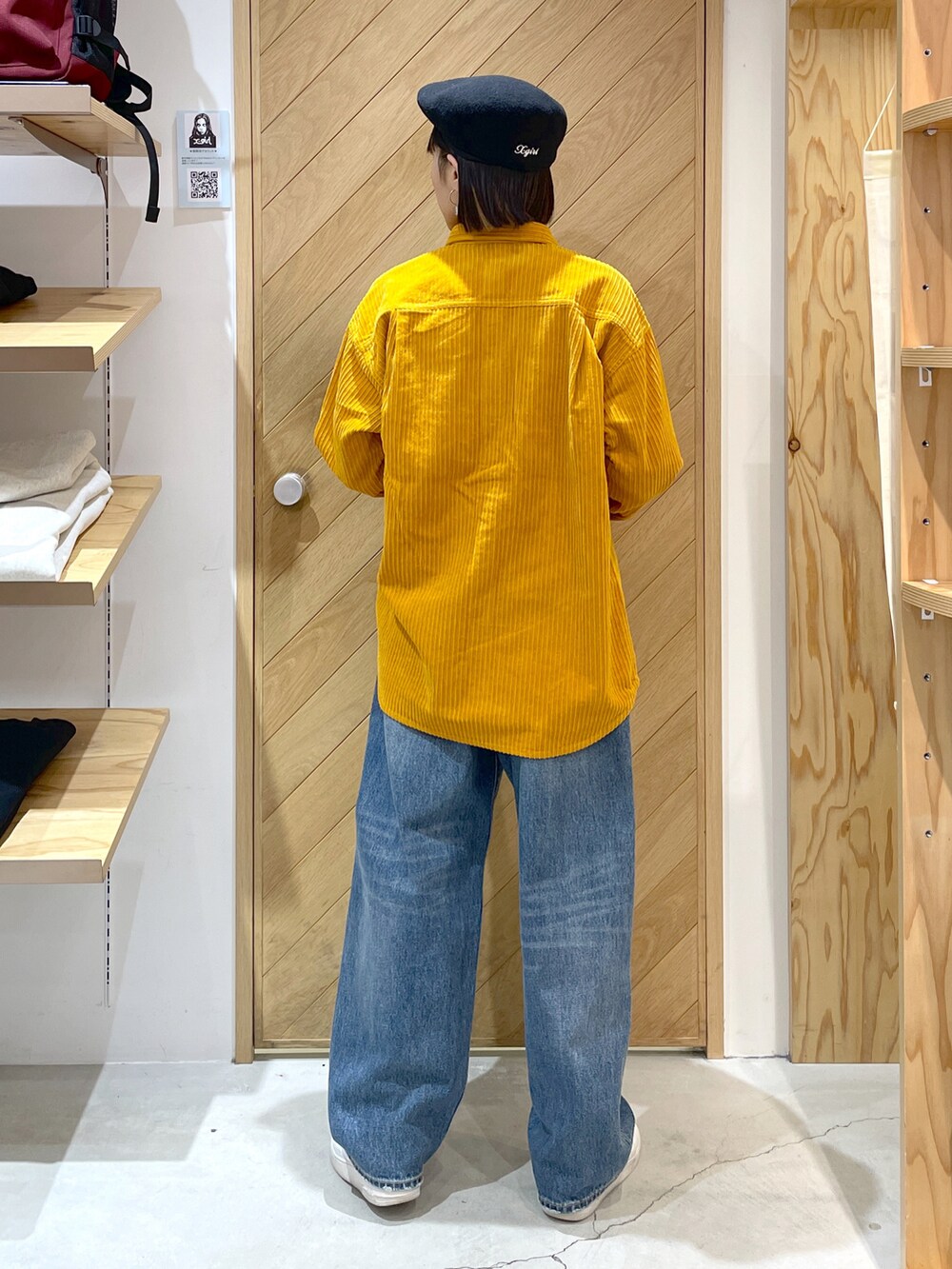 イエロー系のシャツ/ブラウス、ホワイト系のTシャツ/カットソー、ブルー系のデニムパンツを着用したレディースの秋コーディネートの2枚目の写真