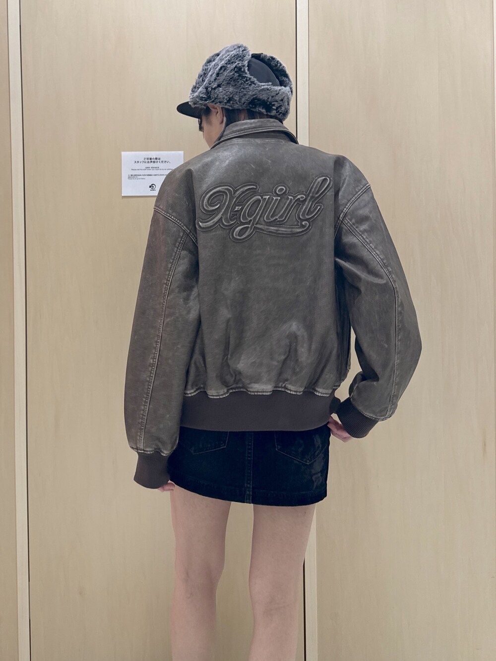 ブラウン系のブルゾン、ホワイト系のTシャツ/カットソー、ブラック系のデニムスカートを着用したレディースの秋コーディネートの5枚目の写真