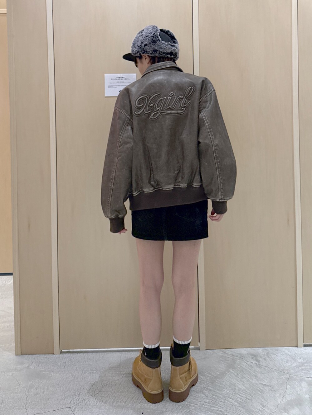 ブラウン系のブルゾン、ホワイト系のTシャツ/カットソー、ブラック系のデニムスカートを着用したレディースの秋コーディネートの3枚目の写真