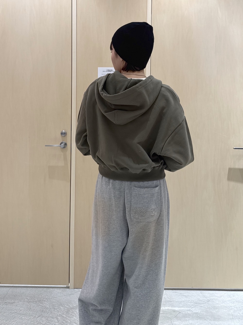 グリーン系のパーカー、ホワイト系のTシャツ/カットソー、グレー系のスウェットパンツを着用したレディースの冬コーディネートの5枚目の写真