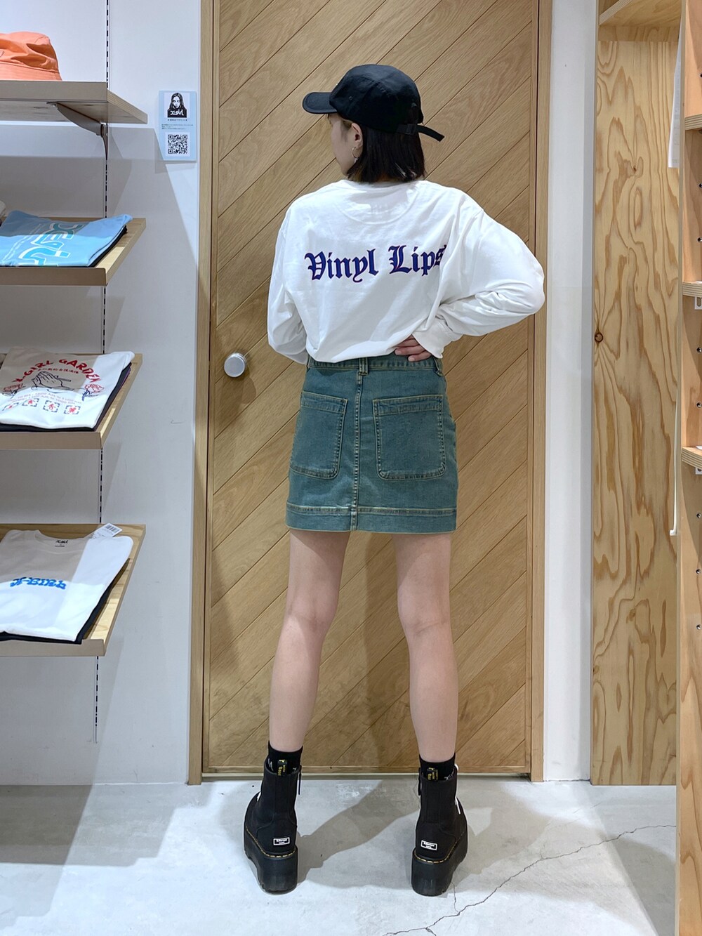 ホワイト系のTシャツ/カットソー、ブルー系のスカート、ブラック系のキャップを着用したレディースの秋コーディネートの2枚目の写真