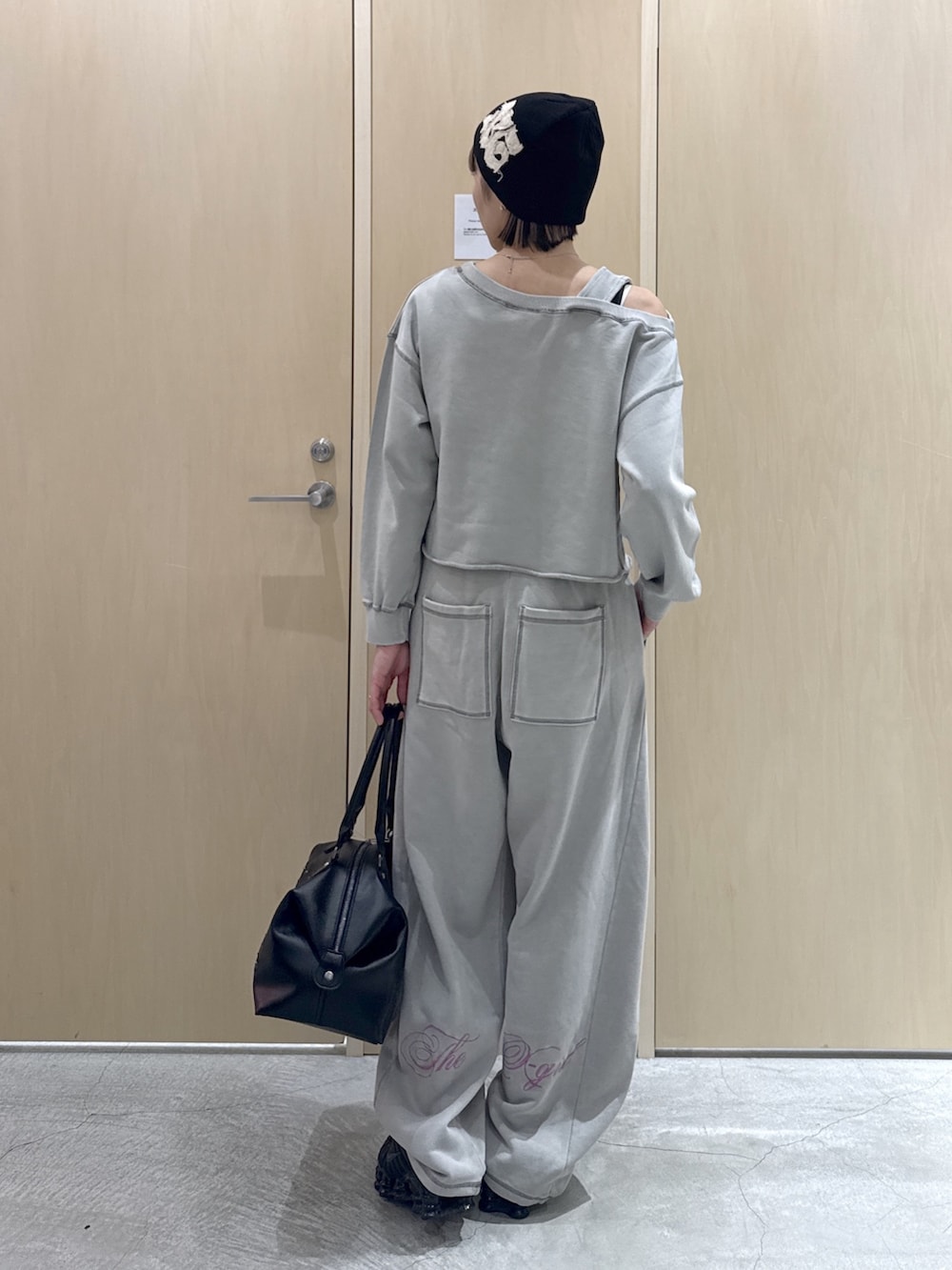 グレー系のスウェット、ブラック系のショルダーバッグ、グレー系のスウェットパンツを着用したレディースの春コーディネートの3枚目の写真