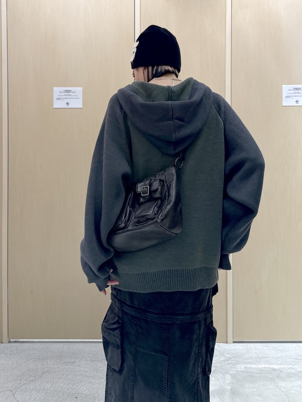 ブラック系のショルダーバッグ、ブラック系のスカート、グリーン系のニット/セーターを着用したレディースの冬コーディネートの5枚目の写真