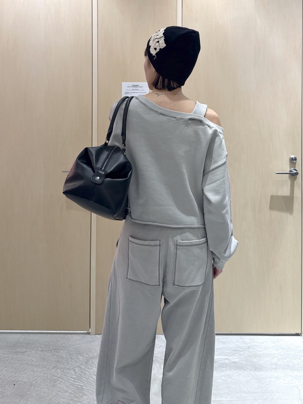 グレー系のスウェット、ブラック系のショルダーバッグ、グレー系のスウェットパンツを着用したレディースの春コーディネートの5枚目の写真