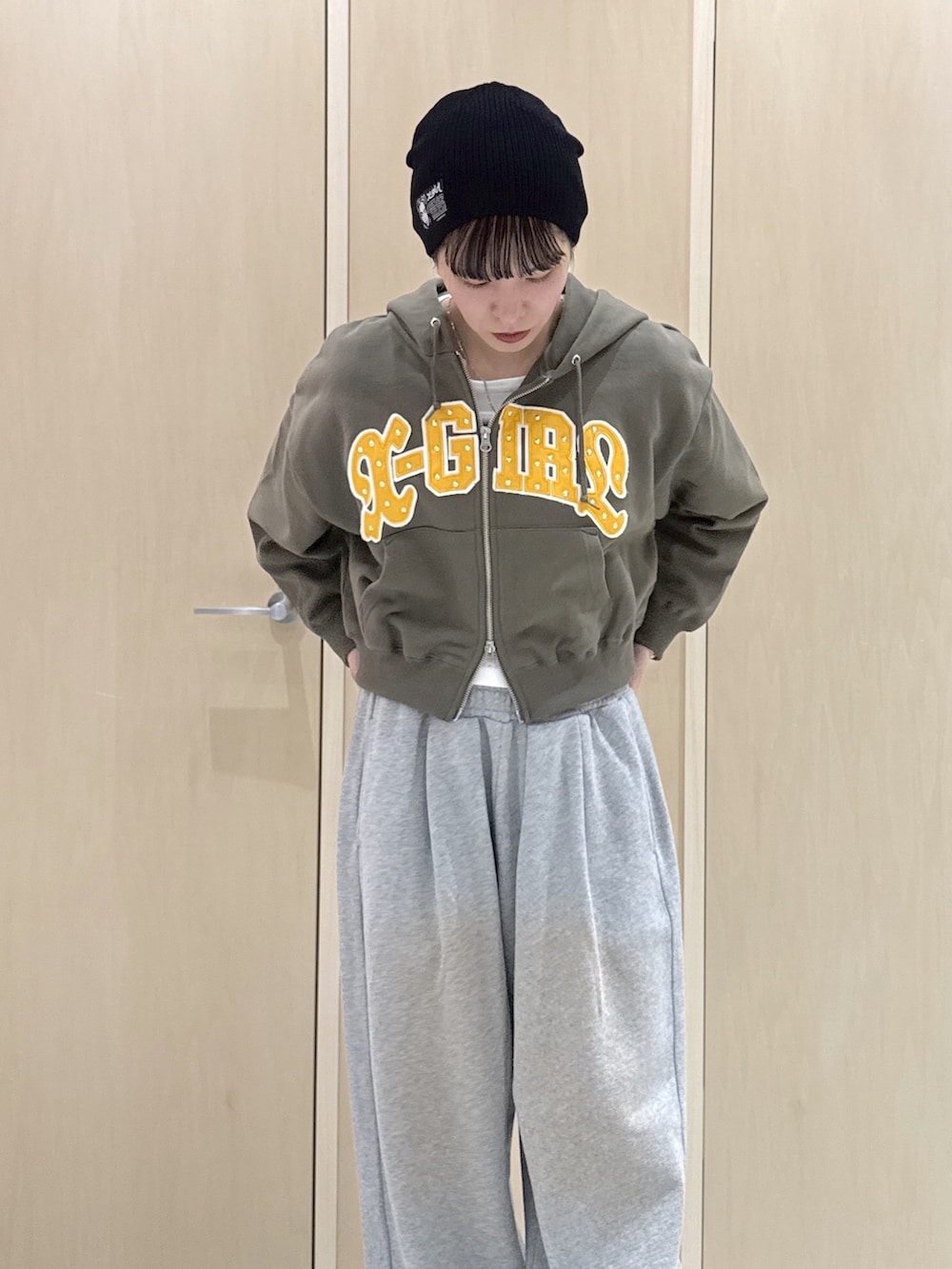 グリーン系のパーカー、ホワイト系のTシャツ/カットソー、グレー系のスウェットパンツを着用したレディースの冬コーディネートの4枚目の写真