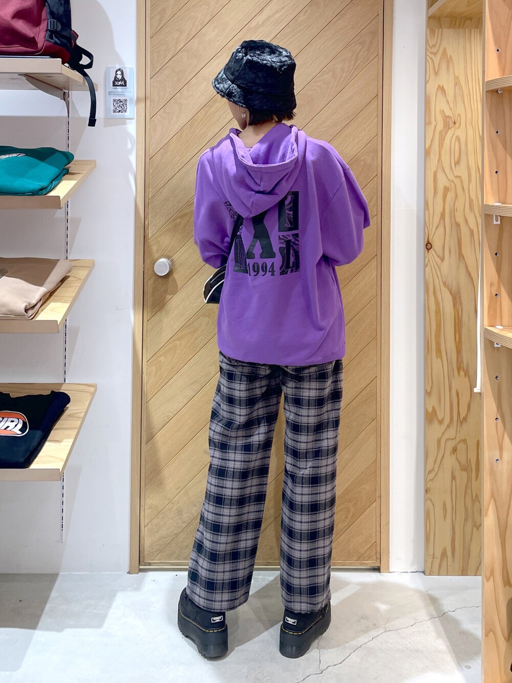 パープル系のパーカー、ブラック系のその他パンツ、ブラック系のショルダーバッグを着用したレディースの秋コーディネートの2枚目の写真