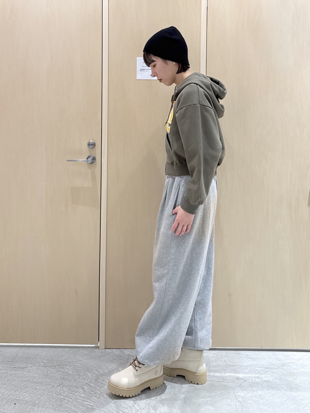 グリーン系のパーカー、ホワイト系のTシャツ/カットソー、グレー系のスウェットパンツを着用したレディースの冬コーディネートの2枚目の写真