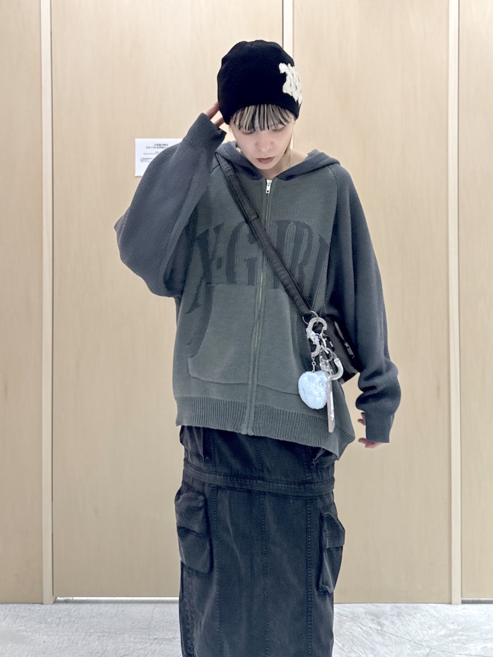 ブラック系のショルダーバッグ、ブラック系のスカート、グリーン系のニット/セーターを着用したレディースの冬コーディネートの4枚目の写真