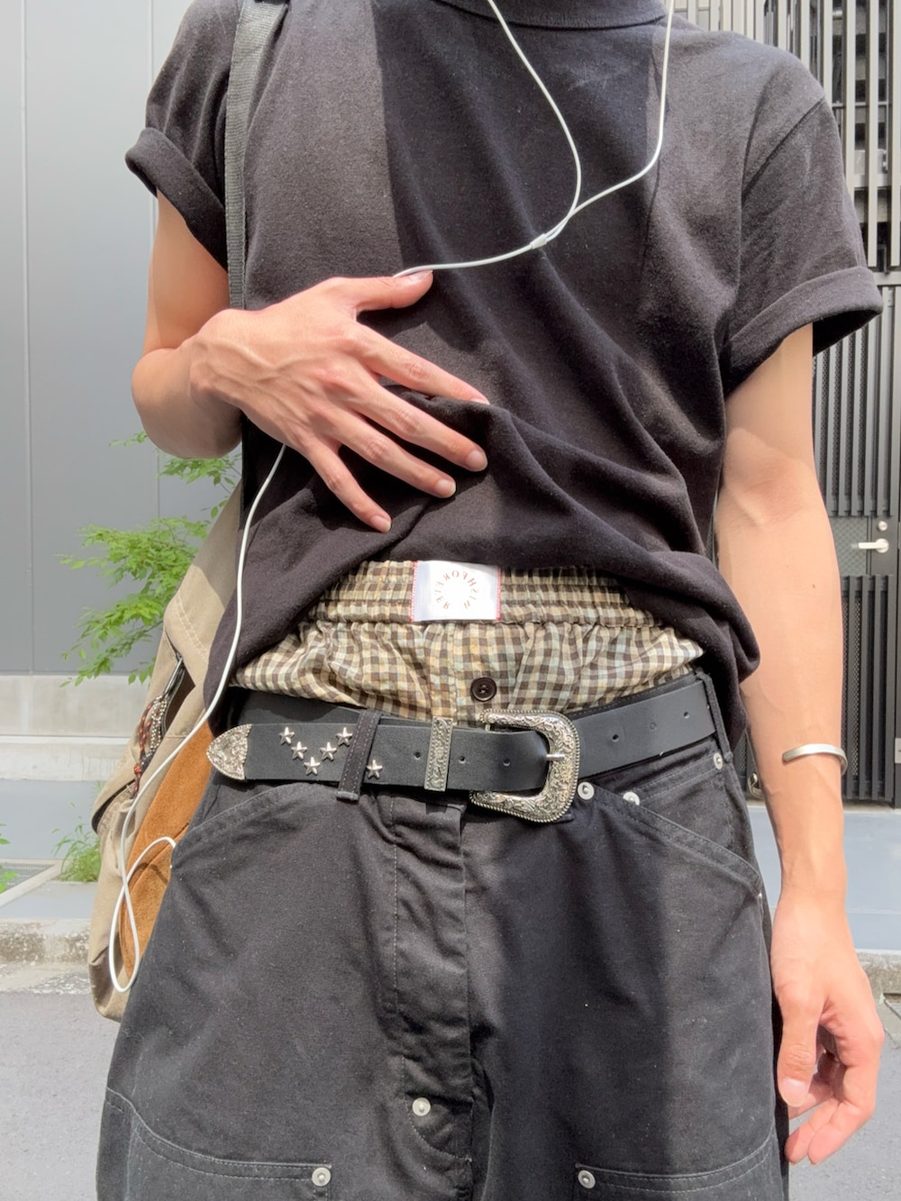 ブラック系のパンツ、レッド系のモカシン/デッキシューズ、ブラック系のTシャツ/カットソーを着用したメンズの夏コーディネートの2枚目の写真