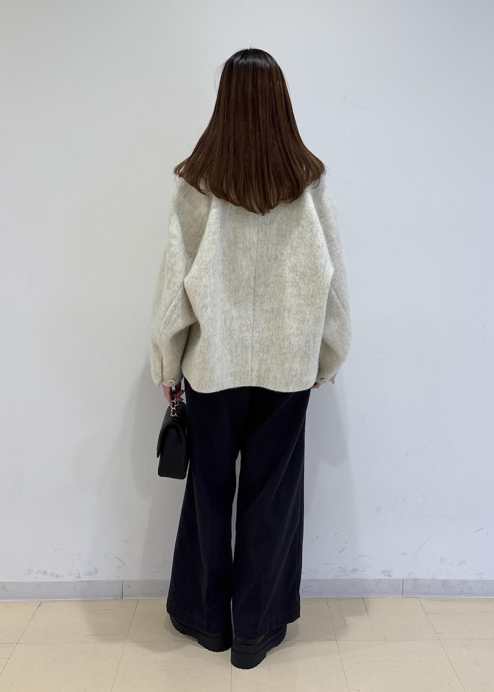 ブラック系のブーツ、ホワイト系のブルゾン、ピンク系のニット/セーターを着用したレディースの冬コーディネートの4枚目の写真