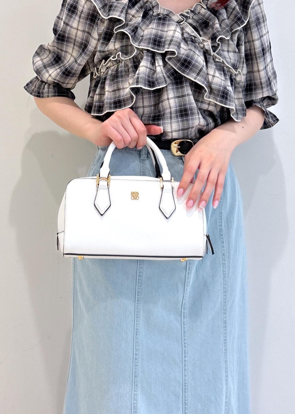 ブラック系のサンダル、ブルー系のデニムスカート、ホワイト系のショルダーバッグを着用したレディースの夏コーディネートの9枚目の写真