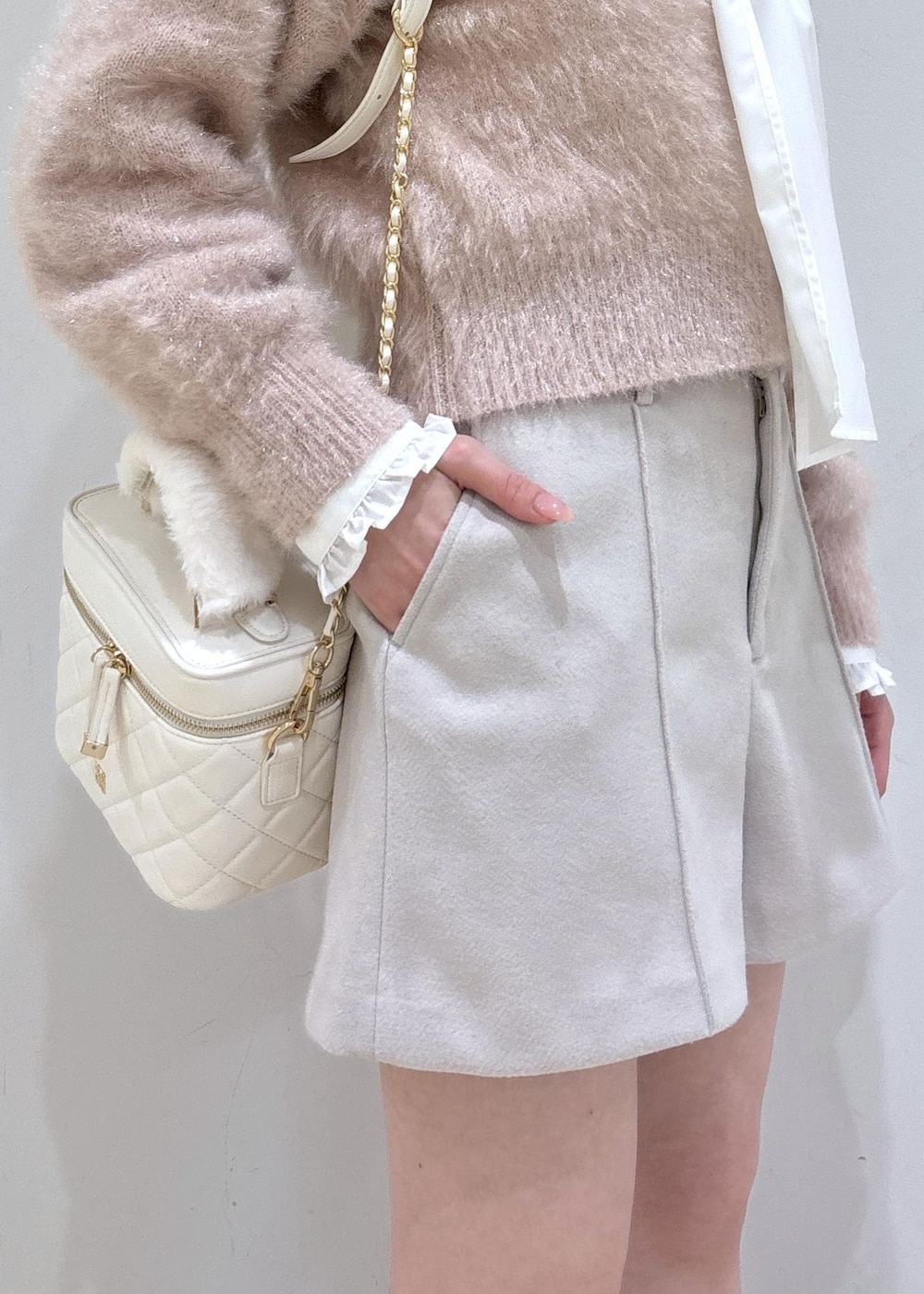 ブラウン系のブーツ、ベージュ系のその他パンツ、ホワイト系のハンドバッグを着用したレディースの冬コーディネートの8枚目の写真