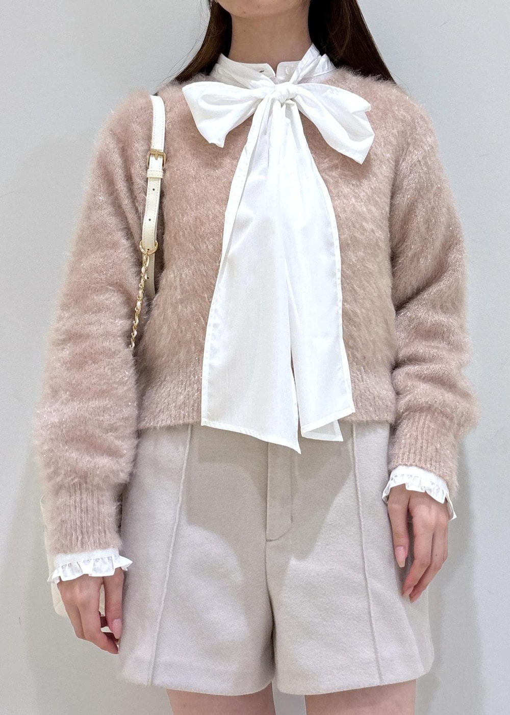 ブラウン系のブーツ、ベージュ系のその他パンツ、ホワイト系のハンドバッグを着用したレディースの冬コーディネートの5枚目の写真