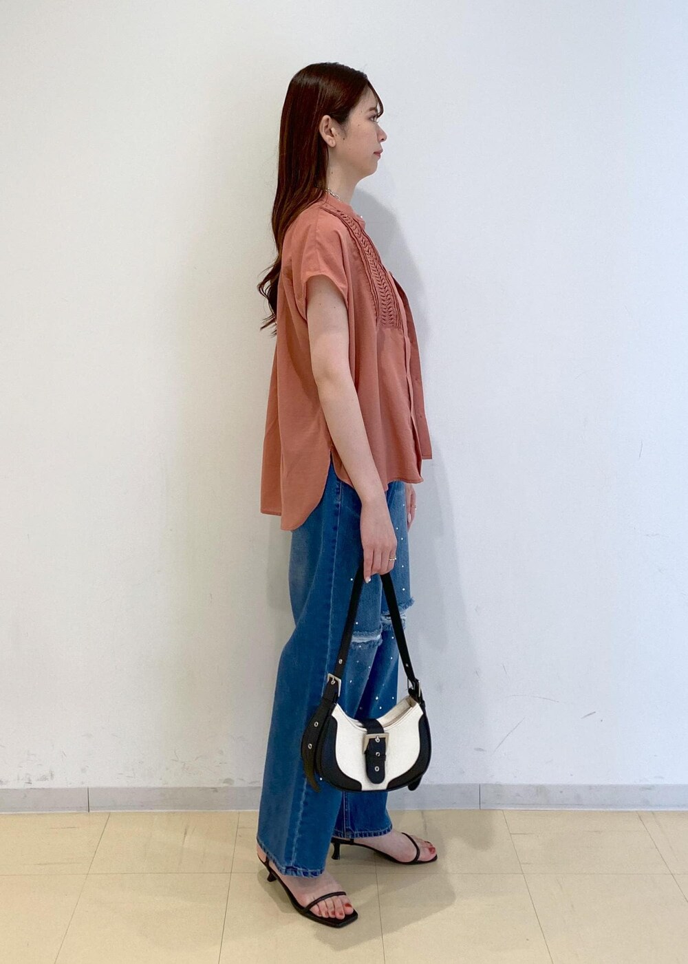 ブルー系のデニムパンツ、ブラック系のサンダル、ブラック系のキャミソールを着用したレディースの夏コーディネートの2枚目の写真