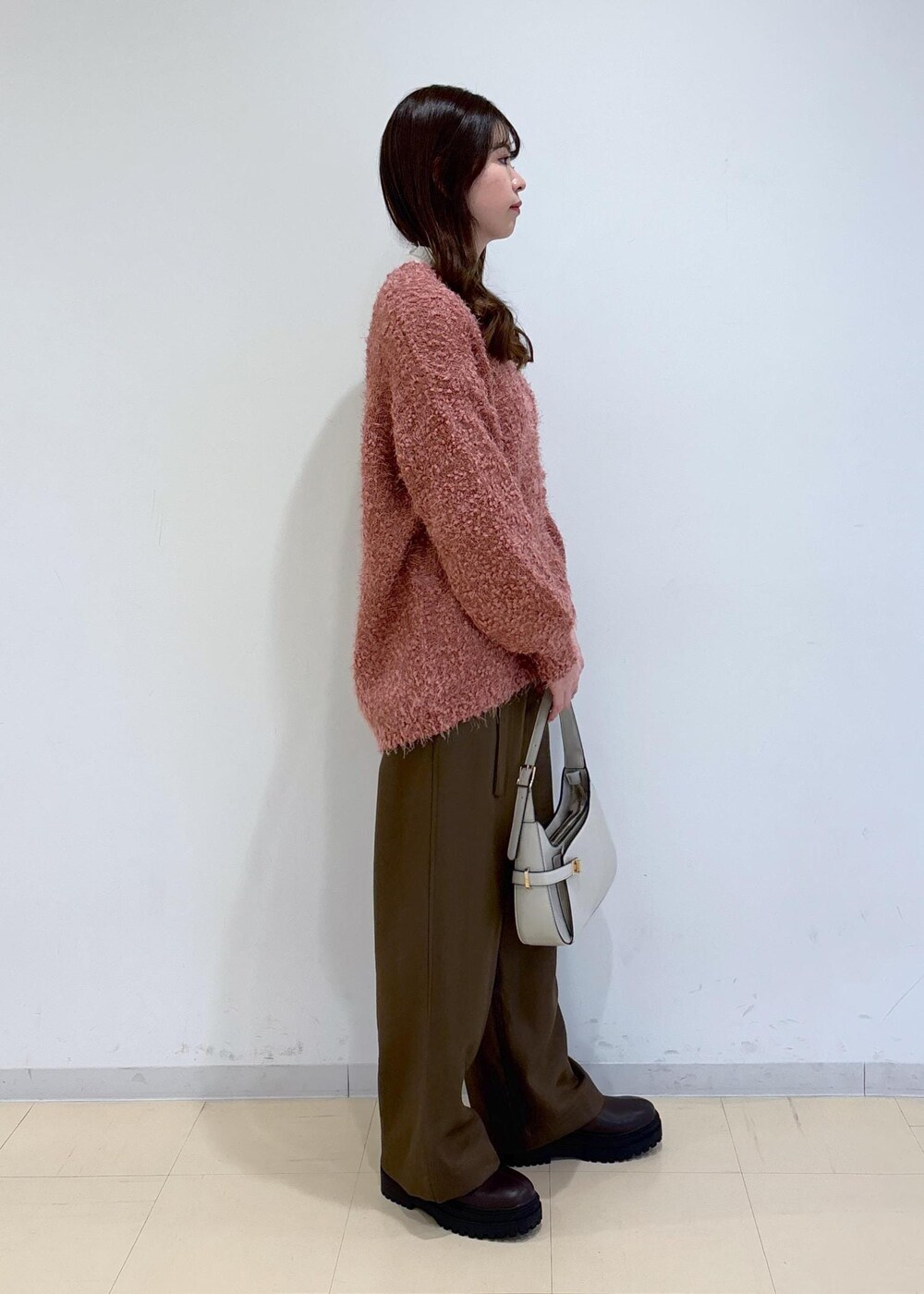 ブラウン系のブーツ、ピンク系のカーディガン/ボレロ、ホワイト系のニット/セーターを着用したレディースの冬コーディネートの4枚目の写真