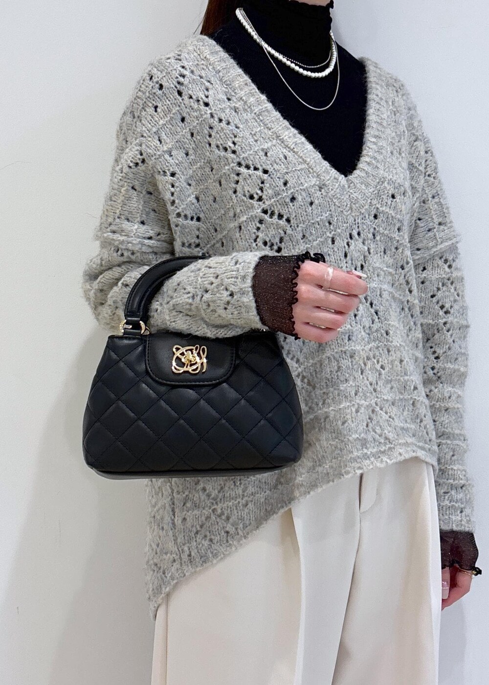 ブラック系のブーツ、ブラック系のTシャツ/カットソー、ベージュ系のニット/セーターを着用したレディースの冬コーディネートの9枚目の写真