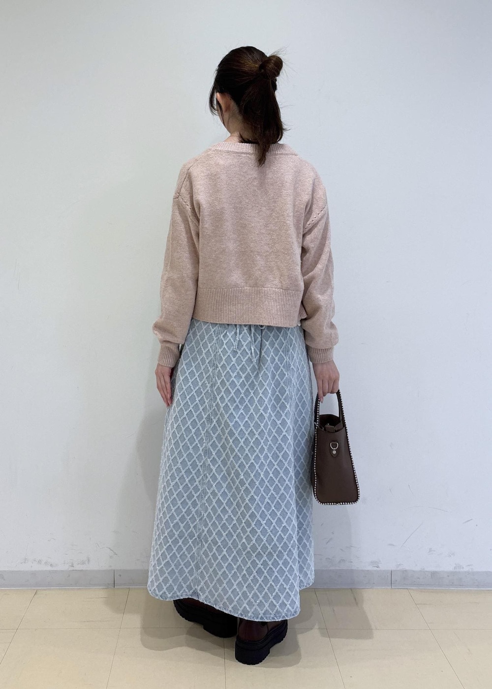 ブラウン系のブーツ、ピンク系のカーディガン/ボレロ、ブラウン系のトートバッグを着用したレディースの冬コーディネートの4枚目の写真