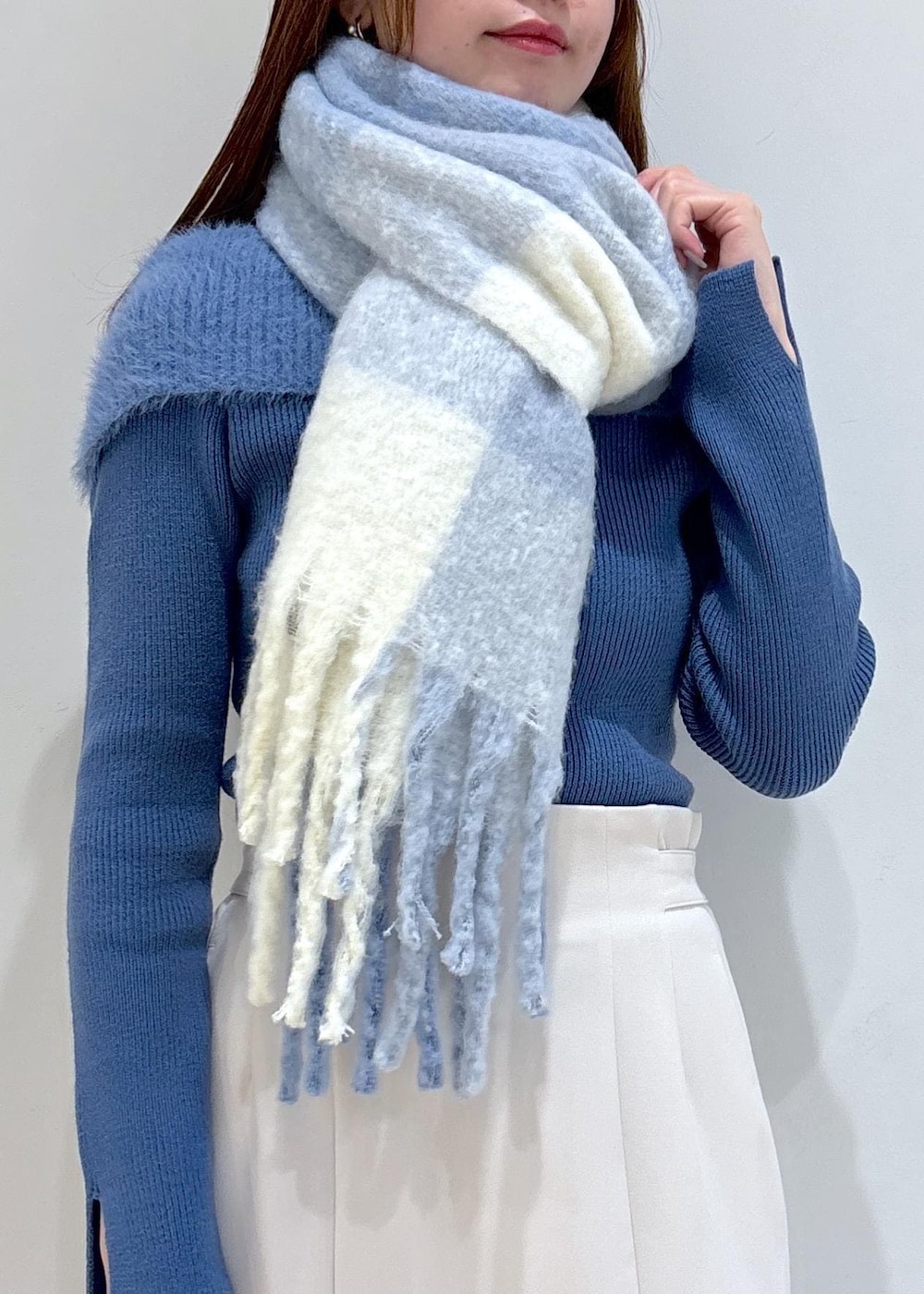 ホワイト系のショルダーバッグ、ブラック系のブーツ、ブルー系のニット/セーターを着用したレディースの秋コーディネートの10枚目の写真