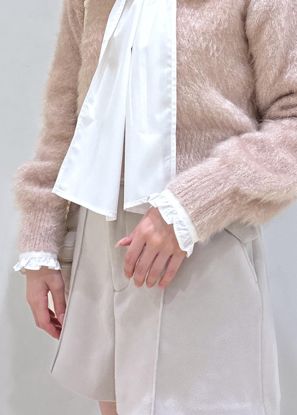 ブラウン系のブーツ、ベージュ系のその他パンツ、ホワイト系のハンドバッグを着用したレディースの冬コーディネートの6枚目の写真