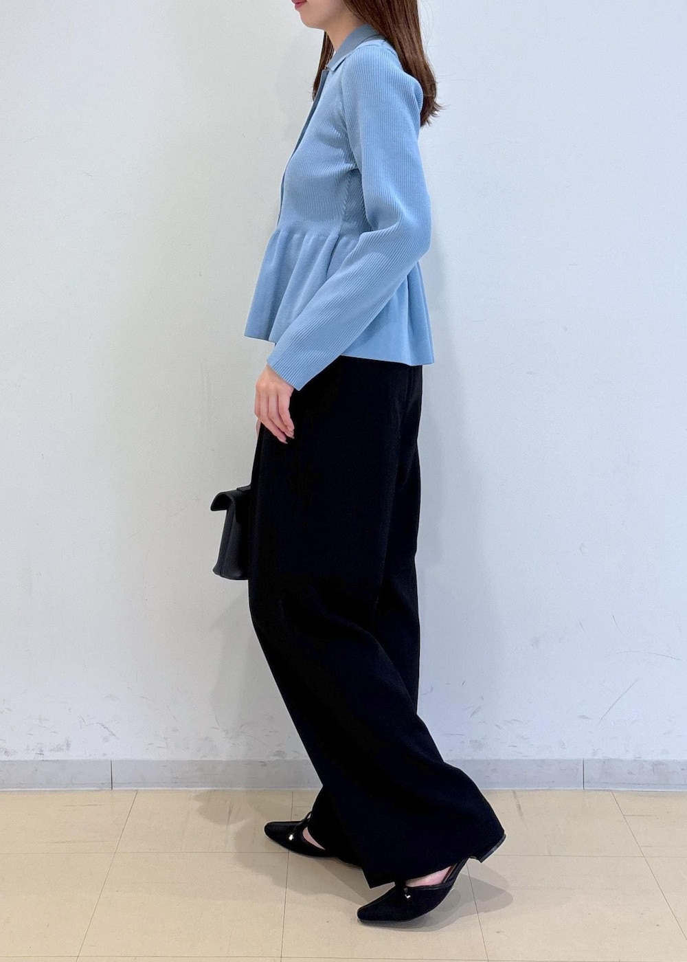 ブラック系のショルダーバッグ、ブラック系のパンプス、ブルー系のカーディガン/ボレロを着用したレディースの秋コーディネートの5枚目の写真