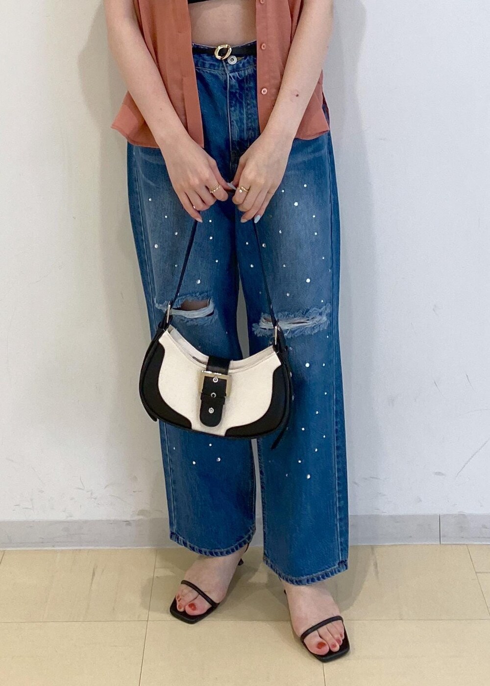 ブルー系のデニムパンツ、ブラック系のサンダル、ブラック系のキャミソールを着用したレディースの夏コーディネートの5枚目の写真