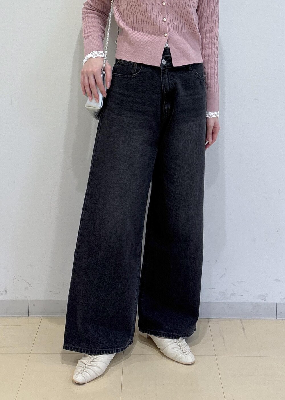 ホワイト系のパンプス、グレー系のデニムパンツ、ホワイト系のTシャツ/カットソーを着用したレディースの冬コーディネートの5枚目の写真