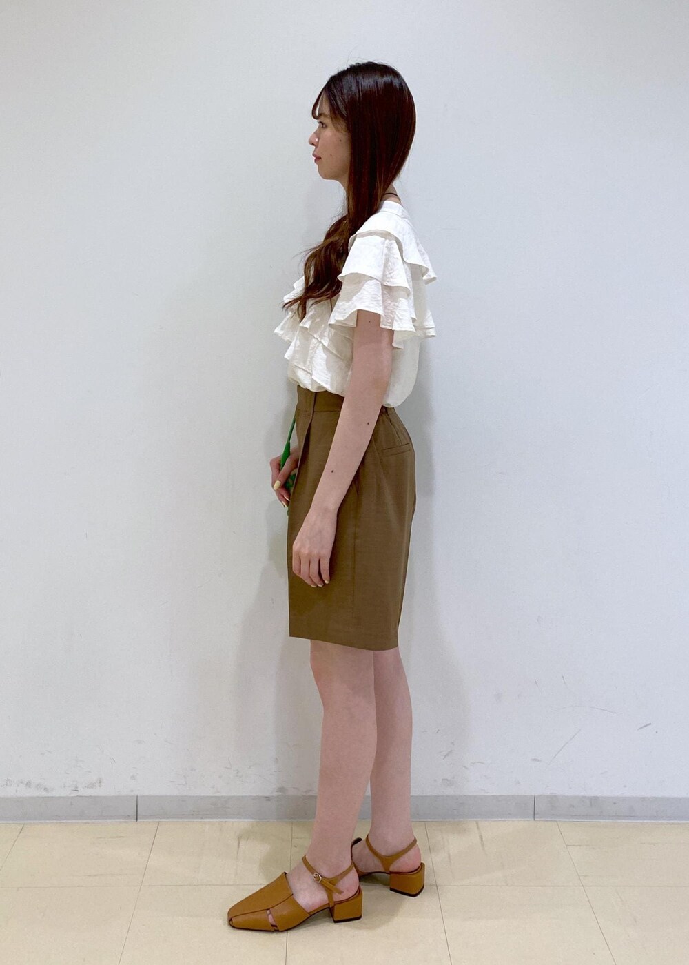 イエロー系のサンダル、ホワイト系のシャツ/ブラウス、グリーン系のショルダーバッグを着用したレディースの夏コーディネートの3枚目の写真