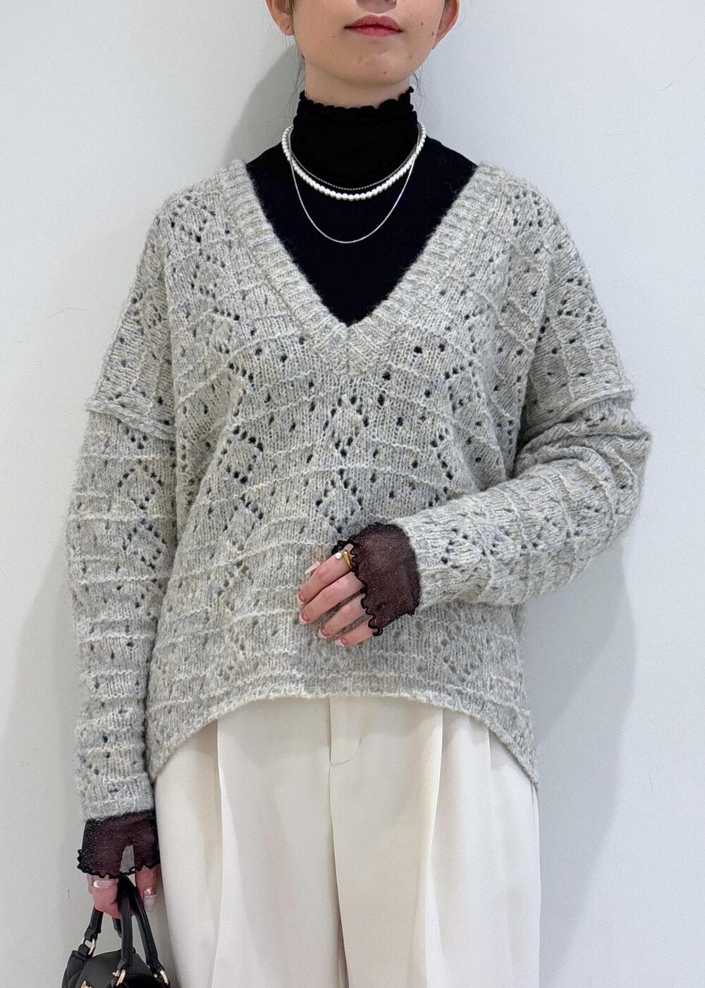 ブラック系のブーツ、ブラック系のTシャツ/カットソー、ベージュ系のニット/セーターを着用したレディースの冬コーディネートの6枚目の写真