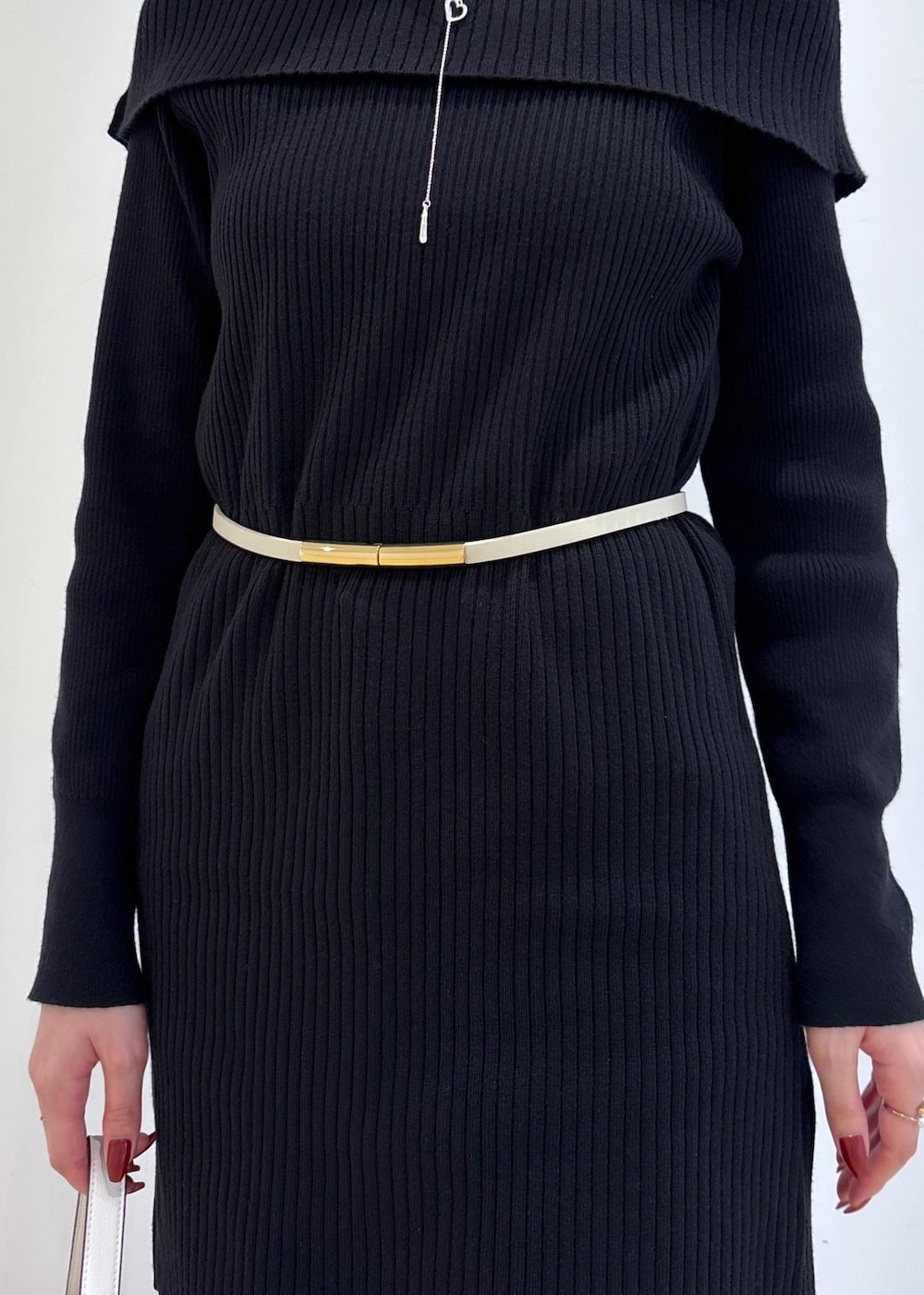 ブルー系のデニムパンツ、ブラック系のブーツ、ホワイト系のショルダーバッグを着用したレディースの秋コーディネートの8枚目の写真