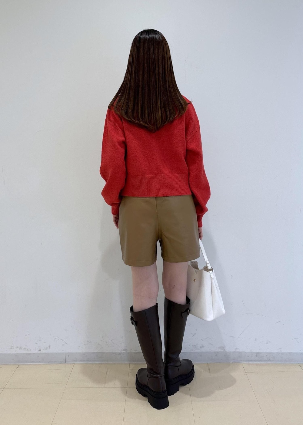 ブラウン系のブーツ、レッド系のカーディガン/ボレロ、ホワイト系のTシャツ/カットソーを着用したレディースの冬コーディネートの5枚目の写真