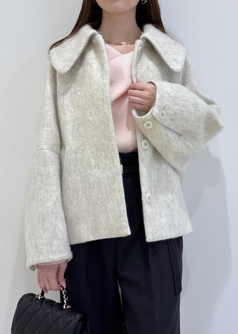 ブラック系のブーツ、ホワイト系のブルゾン、ピンク系のニット/セーターを着用したレディースの冬コーディネートの6枚目の写真