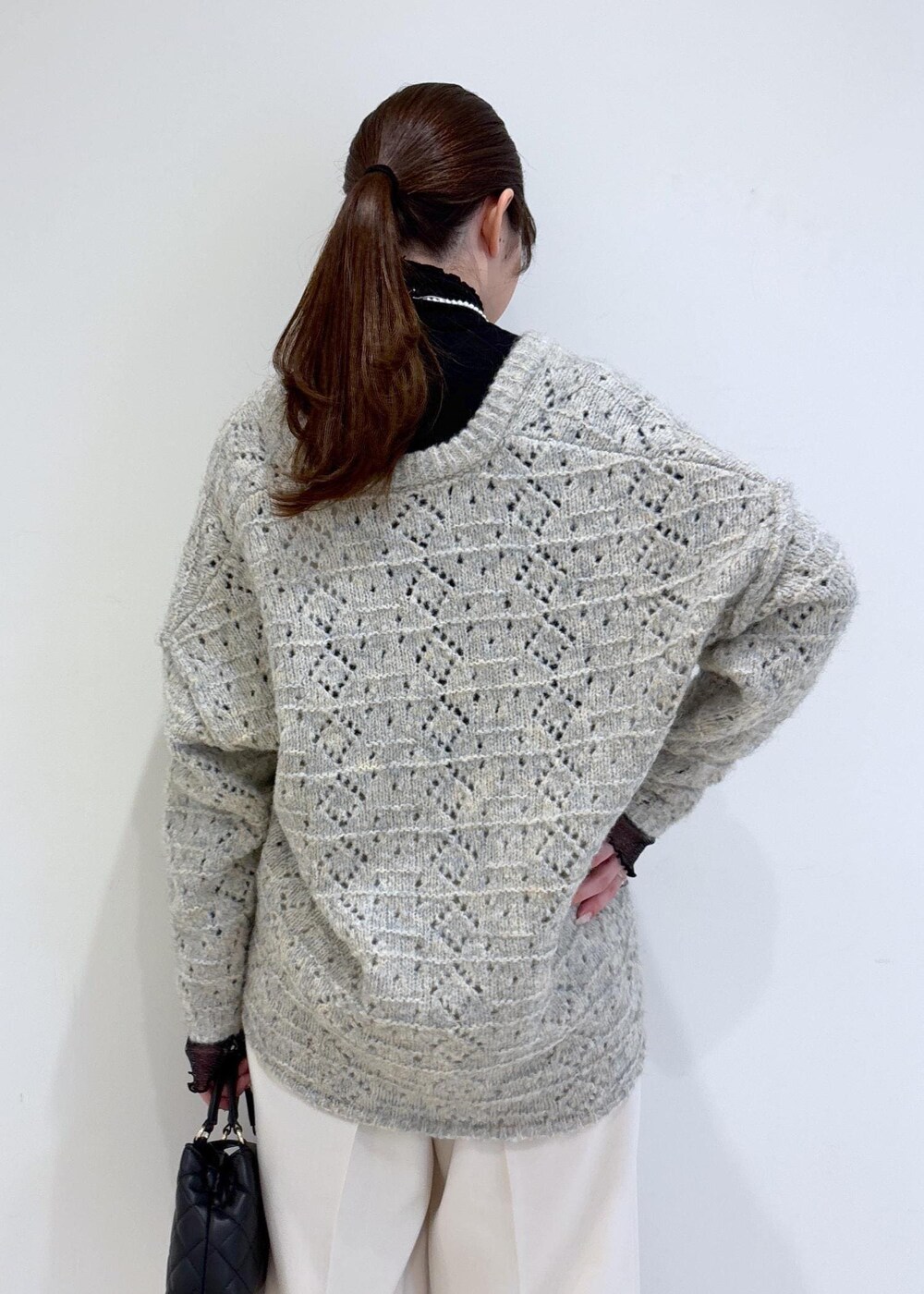 ブラック系のブーツ、ブラック系のTシャツ/カットソー、ベージュ系のニット/セーターを着用したレディースの冬コーディネートの8枚目の写真