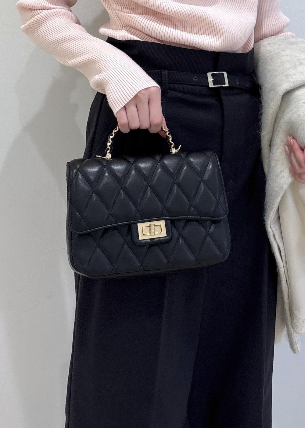 ブラック系のブーツ、ホワイト系のブルゾン、ピンク系のニット/セーターを着用したレディースの冬コーディネートの10枚目の写真