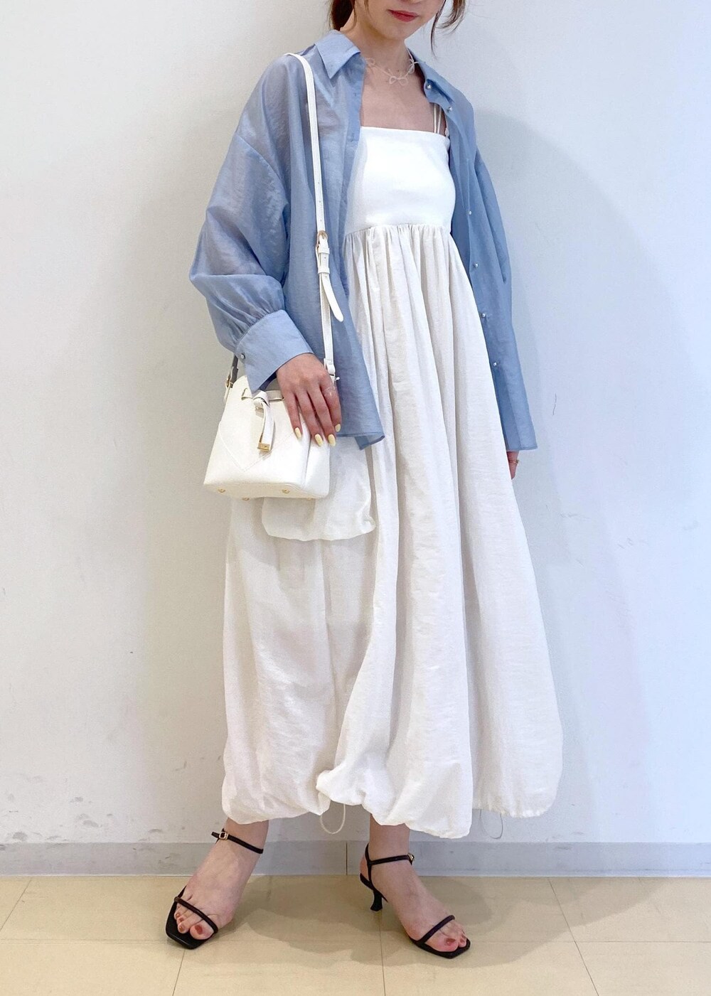 ブラック系のサンダル、ホワイト系のワンピース、ブルー系のシャツ/ブラウスを着用したレディースの夏コーディネートの2枚目の写真