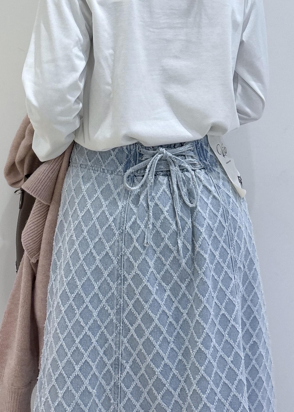 ブラウン系のブーツ、ピンク系のカーディガン/ボレロ、ブラウン系のトートバッグを着用したレディースの冬コーディネートの8枚目の写真