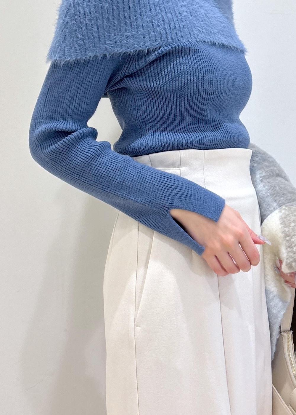 ホワイト系のショルダーバッグ、ブラック系のブーツ、ブルー系のニット/セーターを着用したレディースの秋コーディネートの6枚目の写真