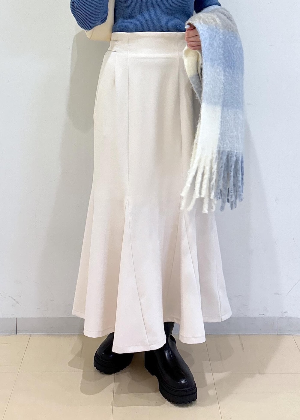 ホワイト系のショルダーバッグ、ブラック系のブーツ、ブルー系のニット/セーターを着用したレディースの秋コーディネートの8枚目の写真