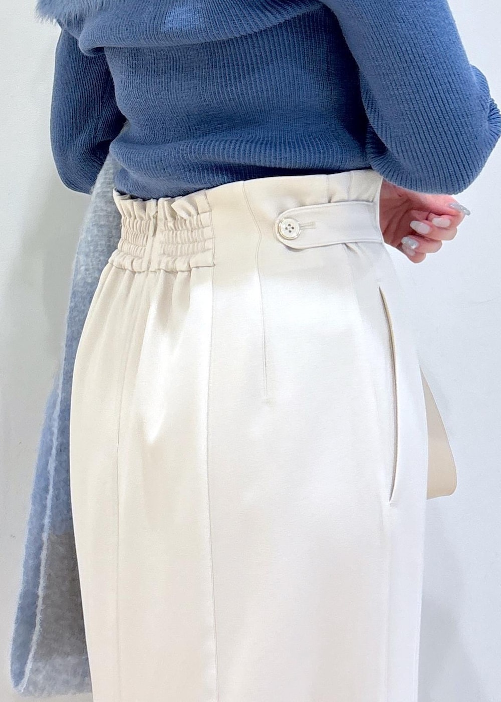 ホワイト系のショルダーバッグ、ブラック系のブーツ、ブルー系のニット/セーターを着用したレディースの秋コーディネートの7枚目の写真