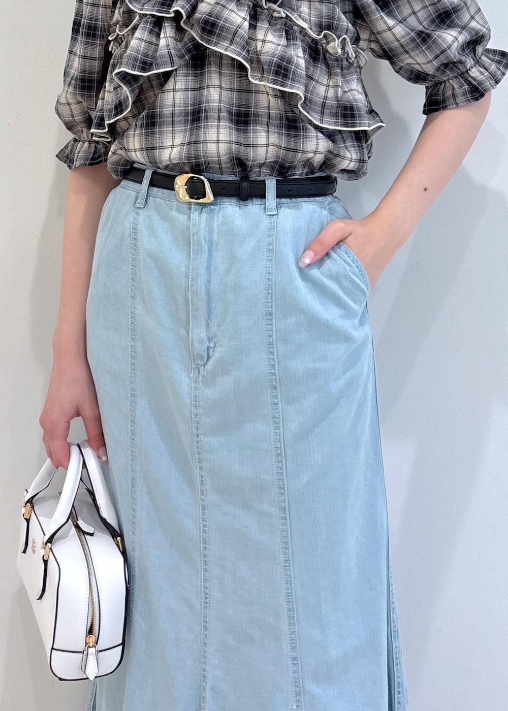 ブラック系のサンダル、ブルー系のデニムスカート、ホワイト系のショルダーバッグを着用したレディースの夏コーディネートの8枚目の写真